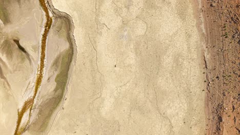 topdown aerial of vast empty lakebed with a single figure walking across dry expanse