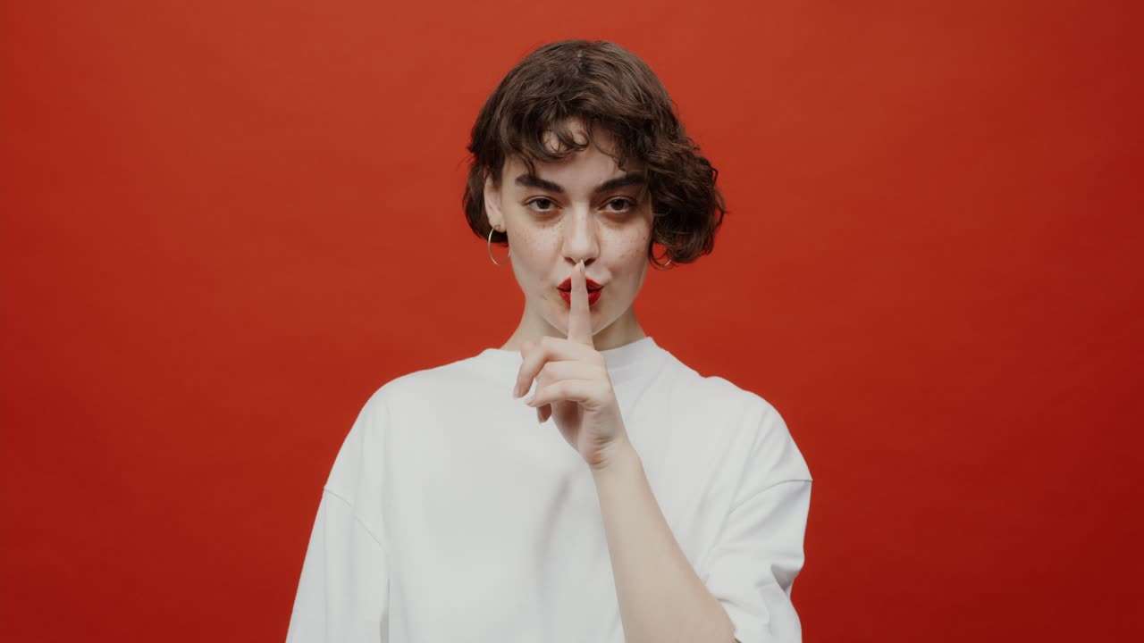 женщина делает жест молчания.