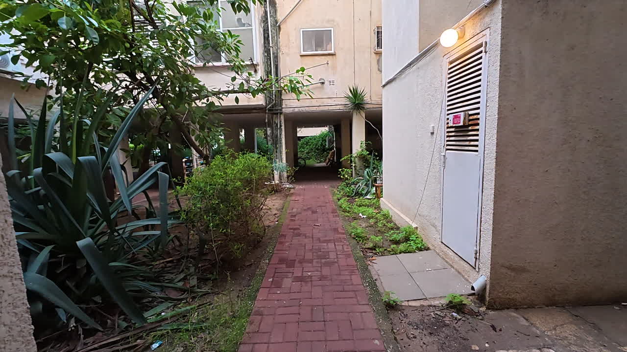 Un tranquillo passaggio lastricato in mattoni attraverso il cortile di un vecchio condominio residenziale a Tel.