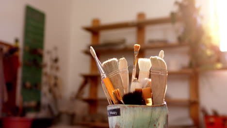 box with pottery brushes on desk in pottery studio