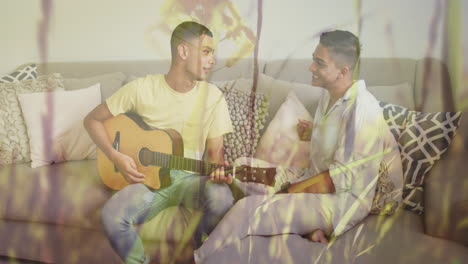 animación de hierba y flores sobre una feliz pareja gay biracial