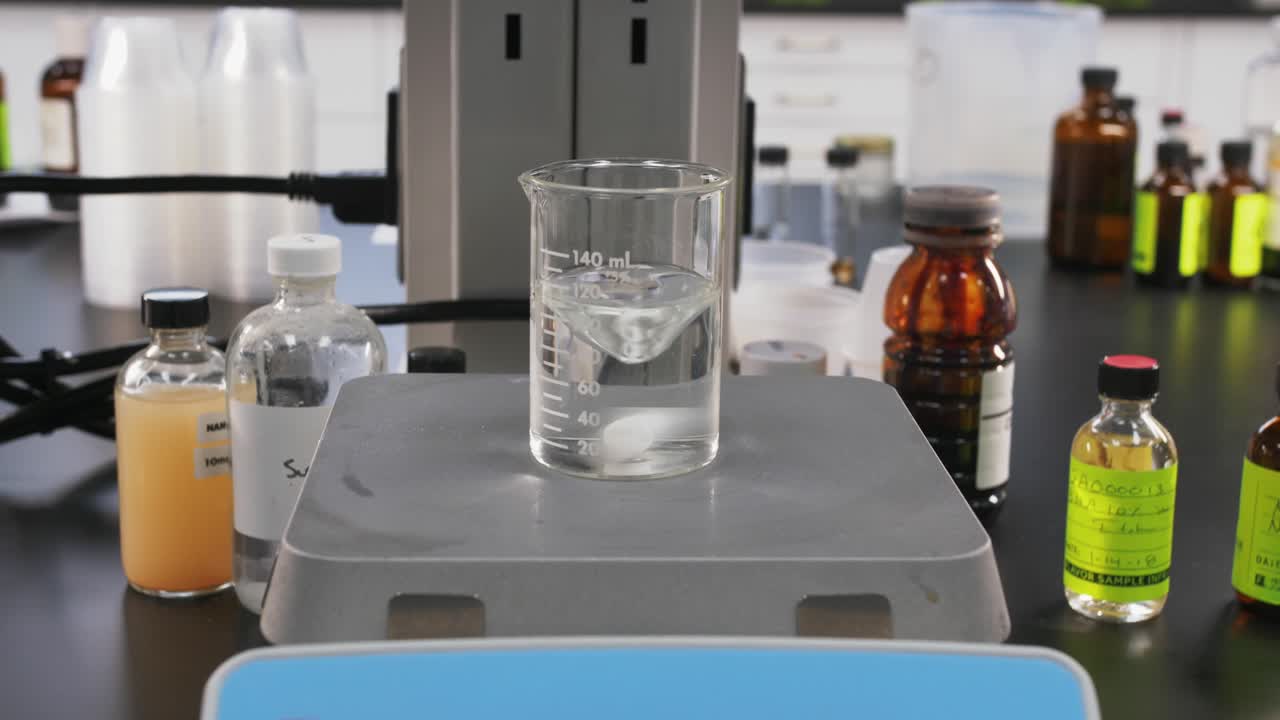 establecimiento de una toma de máquina en un laboratorio de ciencias probando productos químicos en una botella de vidrio transparente