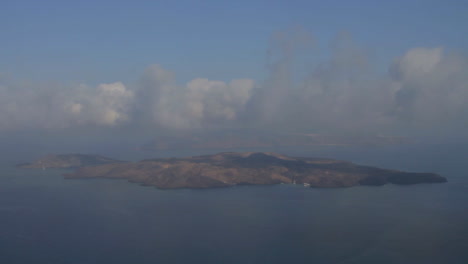 time lapse shot of low altitude clouds traveling over the volcanic island of nea kameni, as seen from the cliffs of santorini