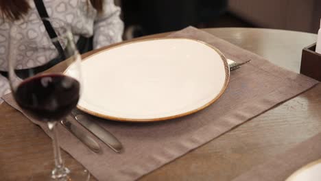 restaurant table setting with empty plate and carpaccio