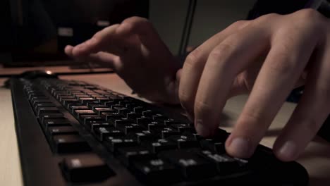 hands typing on a keyboard at night