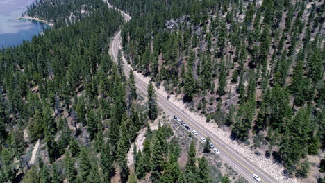 pan and tracking biker on road by lake tahoe