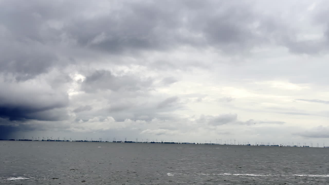 Storm Brews on the North Sea Dark Clouds Gather Over an Offshore Wind Farm, Hinting at the Power of Nature and the Resilience of Green Technology