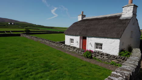 traditional irish cottage with thatched roof and red door