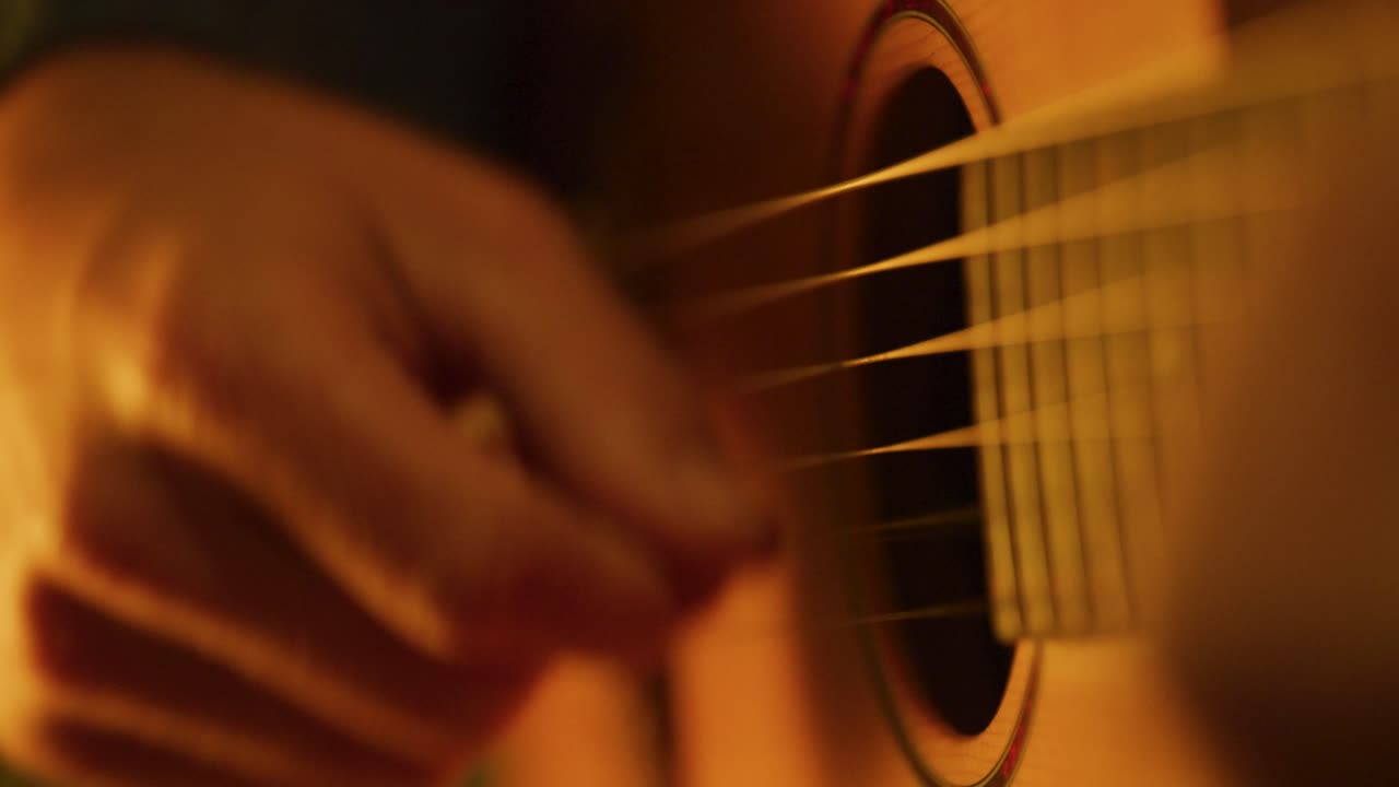 Person playing acoustic guitar moody, close up slow motion 4K