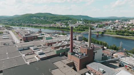 Drone-Journey-Circles-the-Dominant-Twin-Smoke-Stacks-in-Madawaska,-Maine