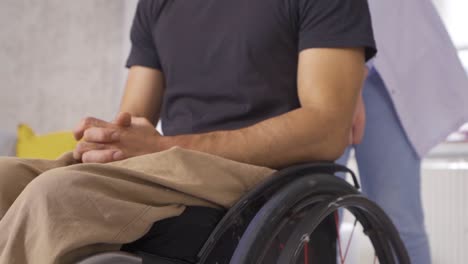 doctor in white medical suit is driving wheelchair of disabled person. slow motion.