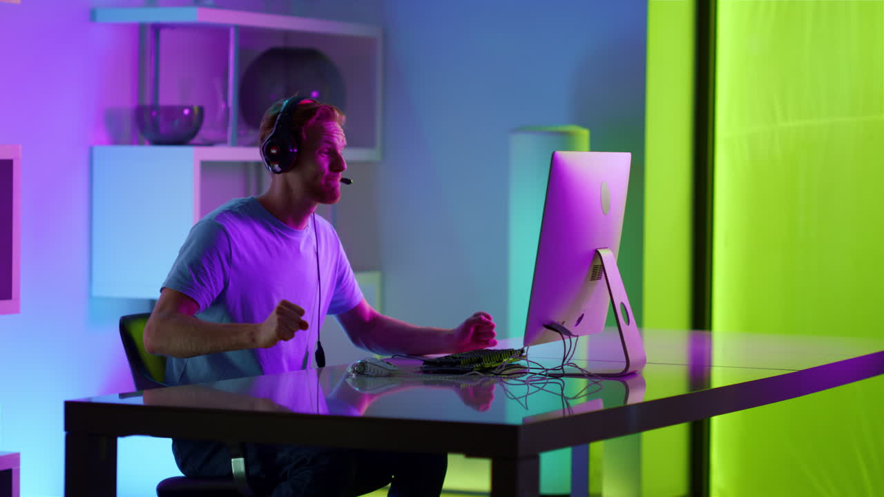 hombre emocionado celebrando la victoria en el torneo de juegos en el ciberespacio de neón en casa.