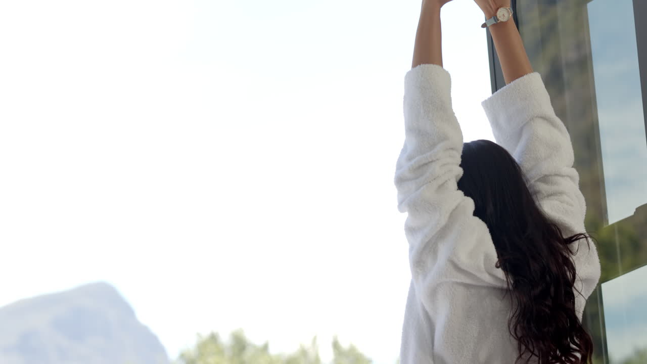 una adolescente biracial feliz estirándose en el balcón soleado por la mañana, copia el espacio, cámara lenta