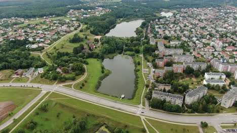 Pequeños-Estanques-De-Agua-Cerca-Del-Gran-Distrito-De-Vida-Con-Edificios-Privados-Y-De-Apartamentos-De-Jonava,-Vista-Aérea-De-Drones