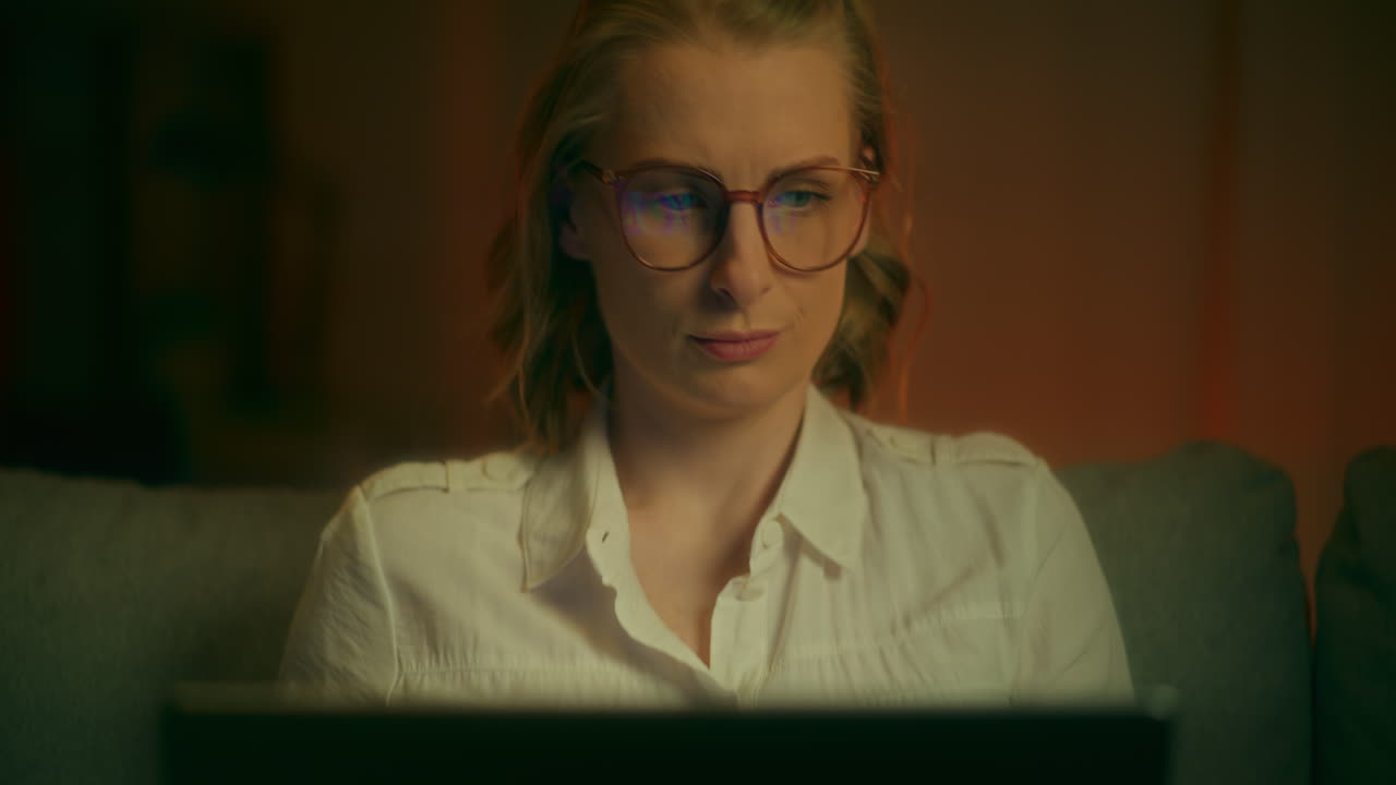 Close Up Of Woman's Face Working Late On Laptop