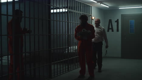 Gefängnisangestellter-Sperrt-Verbrecher-In-Orangefarbener-Uniform-In-Gefängniszelle-Ein