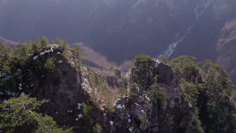 Flying-over-a-mountain-top-to-reveal-a-valley-with-dry-river