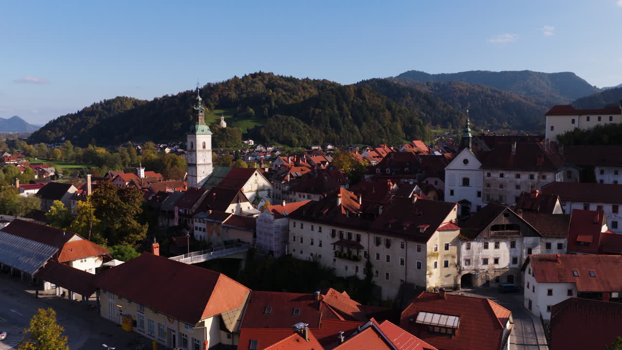 Città medievale preservata con la chiesa di San Giacomo a Škofja Loka durante la stagione autunnale in Slovenia. Ripresa aerea con drone