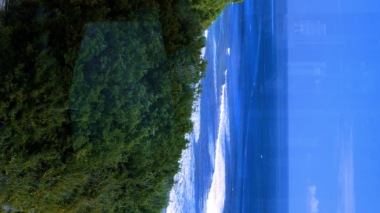 바리의 수루반 해변에 조용히 부 ⁇ 히는 평화로운 파도와 함께 오후 늦게 해변 쪽 수영장 의 수직 정적  ⁇