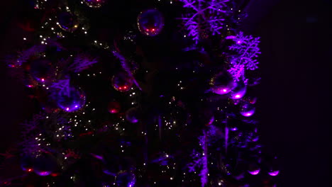 Christmas-tree-decorations-at-night-with-purple-lights---camera-rotate-around-the-tree-and-push-out