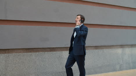 vue latérale homme parlant au téléphone avec son partenaire à l'extérieur. homme d'affaires ayant une conversation téléphonique