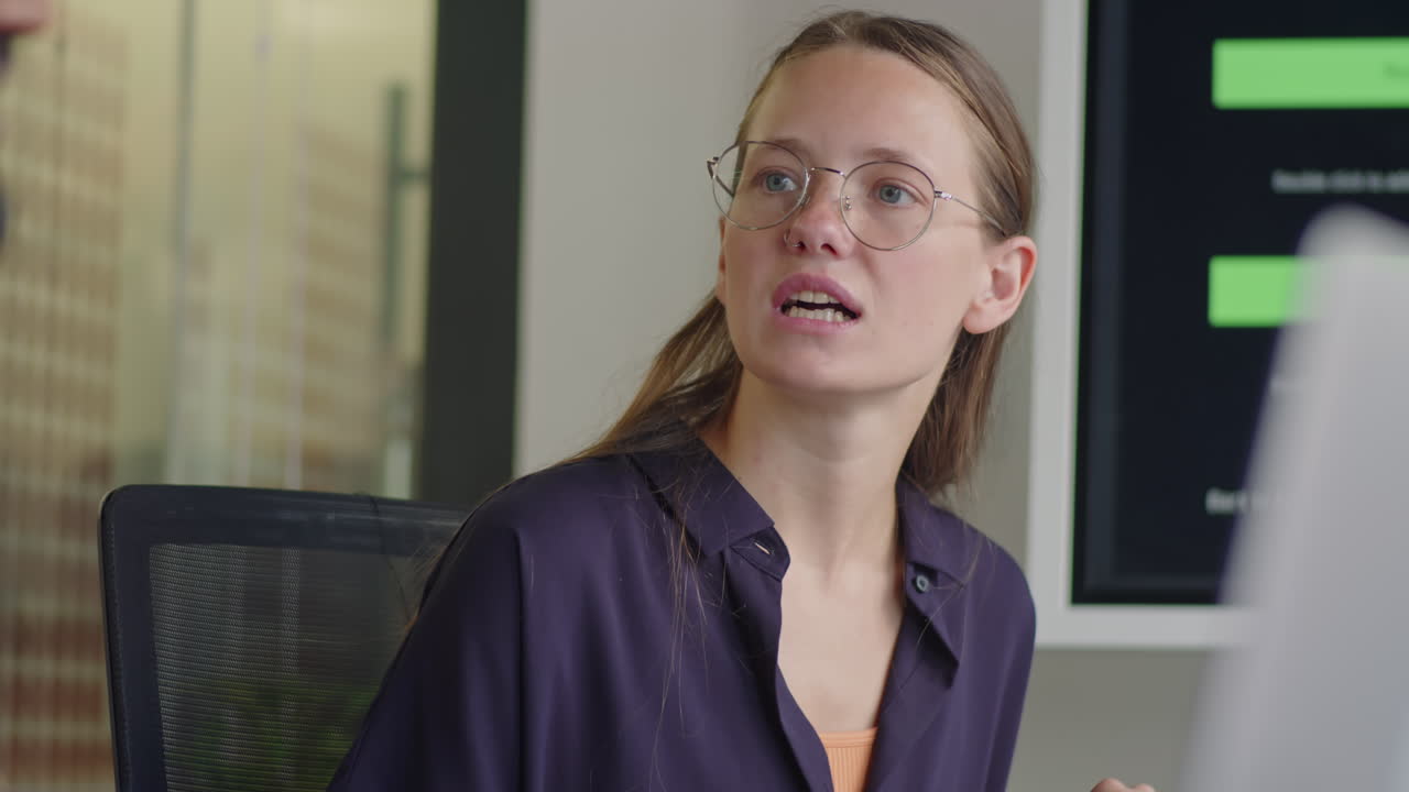 Young Woman Listening to Colleague on Business Meeting