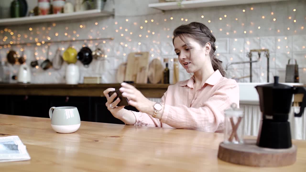 Donna che usa lo smartphone in cucina