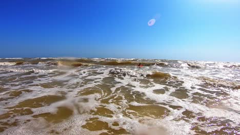 white foam on the dirty sea water. big waves breaking on the shore. happy child is having fun in the sea in summer.
