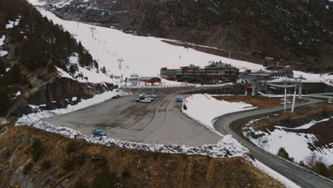 el dron vuela hacia la pista de esquí durante el día sobre el aparcamiento con nieve