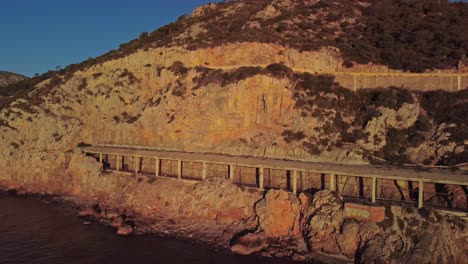 A-scenic-view-of-Port-Ginesta's-rocky-coastline-at-sunrise-in-Barcelona,-Spain