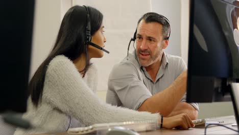 Business-colleagues-discussing-over-computer-at-desk-4k