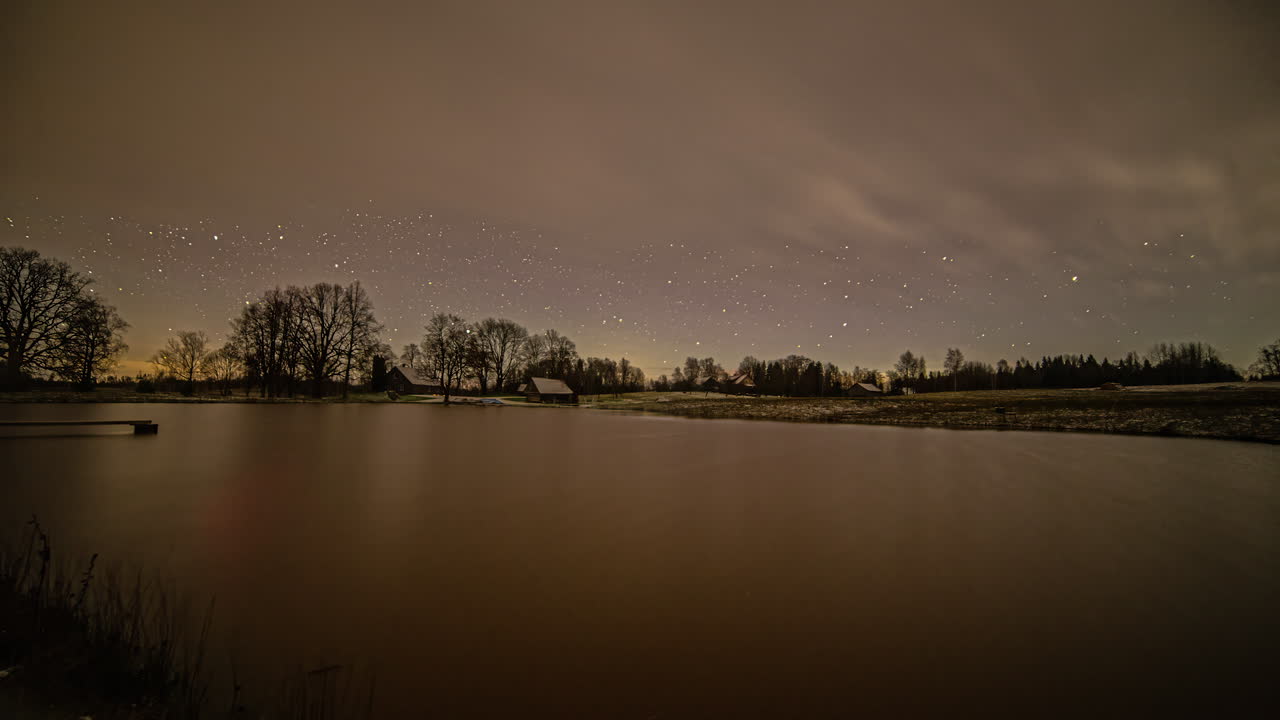 시간 경과에 숲과 오두막이 있는 호수