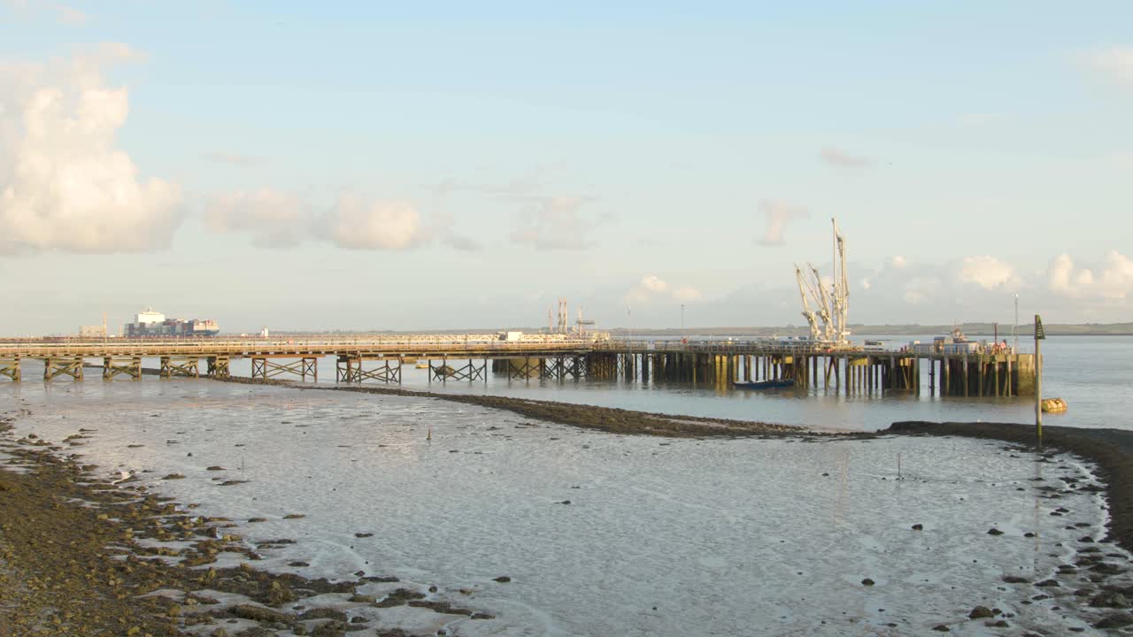 Industrial pier with cargo ships moving in the background