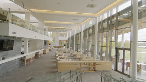 spacious modern restaurant interior with bar and large glass walls