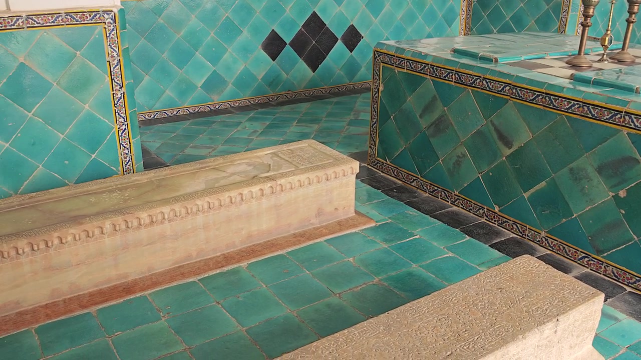 Sarcofago in pietra ornato in un tradizionale mausoleo persiano piastrellato