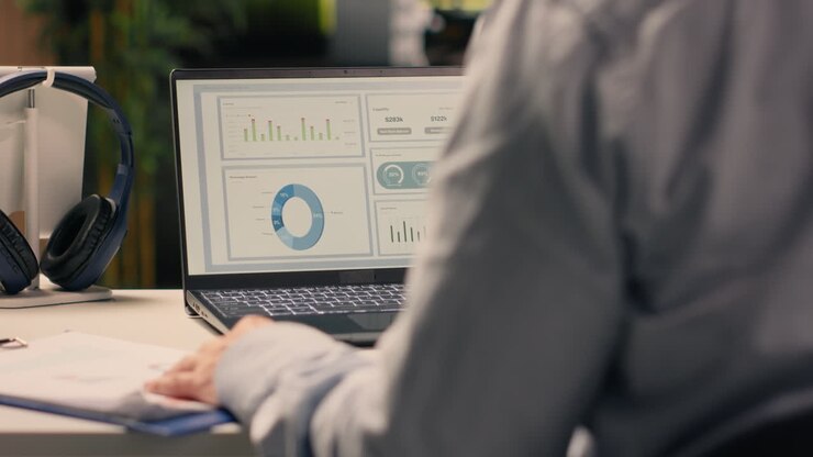 Male office worker solving tasks independently on laptop at desk