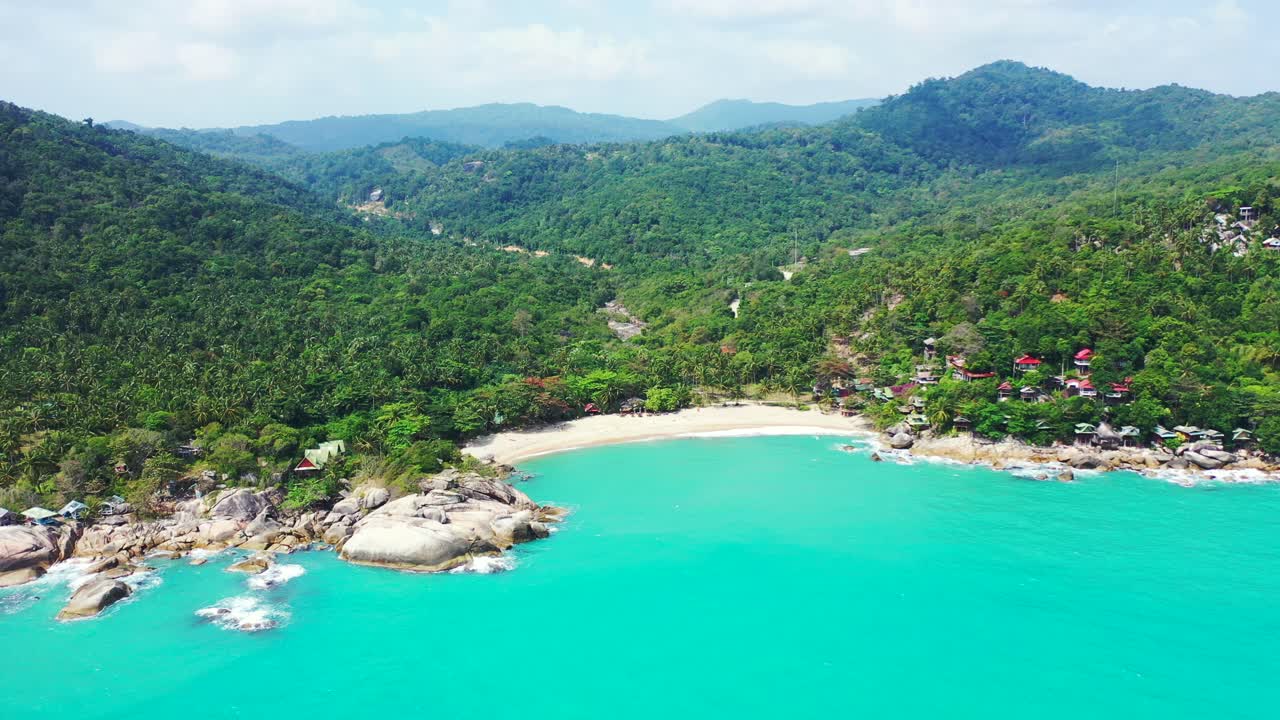 Beautiful tropical island with green hills full of rainforest, secret white sandy beach and cliffs on shore washed by turquoise lagoon, Thailand
