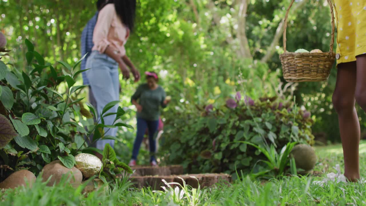animación de una feliz familia afroamericana en busca de huevos de pascua en el jardín