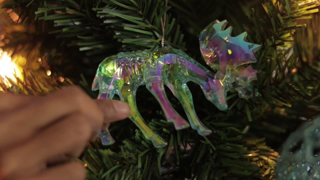 Raddrizzare la decorazione iridescente di alce di cristallo sull'albero di Natale
