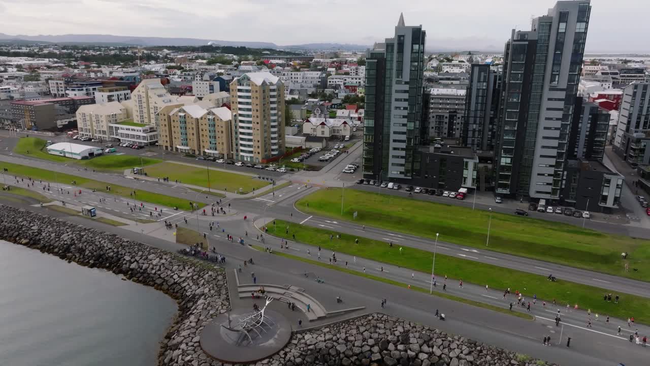 horizonte de reykjavik durante el maratón anual con personas corriendo en la calle costera