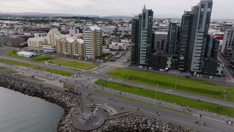 skyline of reykjavik during yearly marathon with people running on coastal street