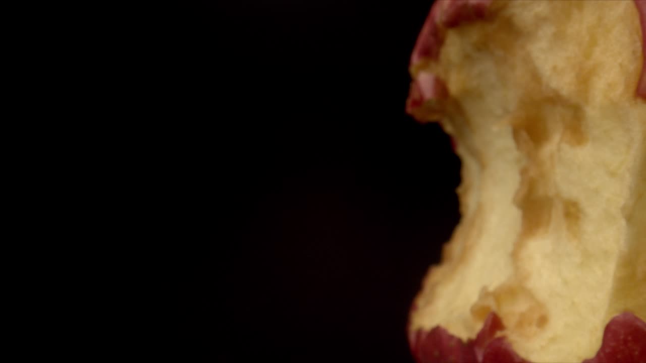 un trozo de una manzana grande sobre un fondo negro, de cerca. concepto de comida, el concepto de comida útil y sabrosa y fruta. toma macro de una manzana mordida.