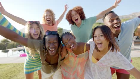 portrait of happy diverse friends embracing and having fun at sunny pool party, slow motion