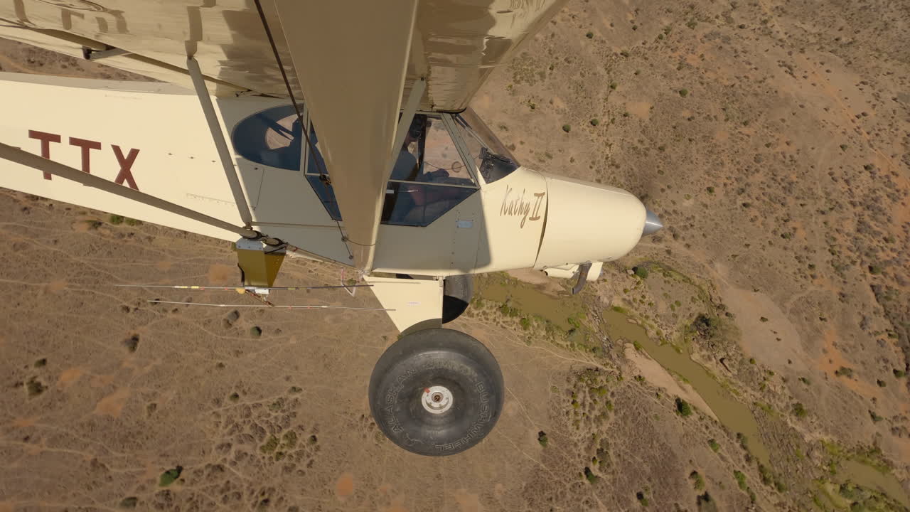 Small Bushcraft plane flying over a dry savannah