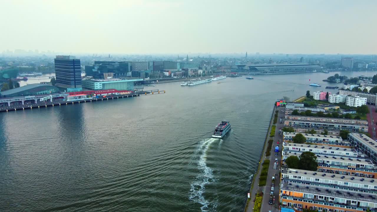 Yacht Cruising On The IJ River In The Early Morning In Amsterdam, Netherlands. - aerial shot