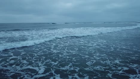 view from a drone flying close to the ocean showing waves