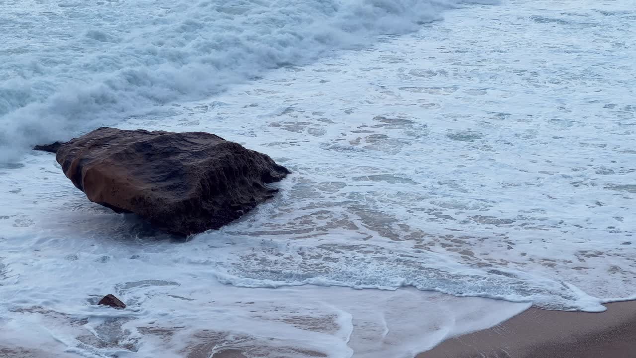 저녁노을이 지는 해변에서 편안하게 휴식을 취하는 사람들이 잔잔한 파도를 즐기고 있어요.