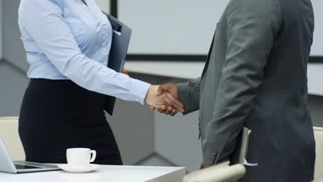 mid-section of multiethnic business partners shaking hands