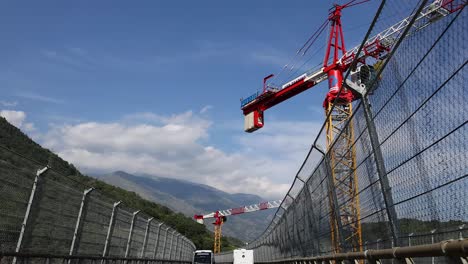 crane operating above highway with passing vehicles