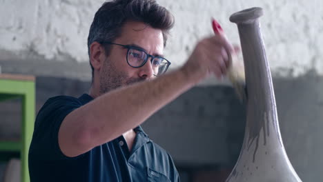 artist painting a ceramic vase